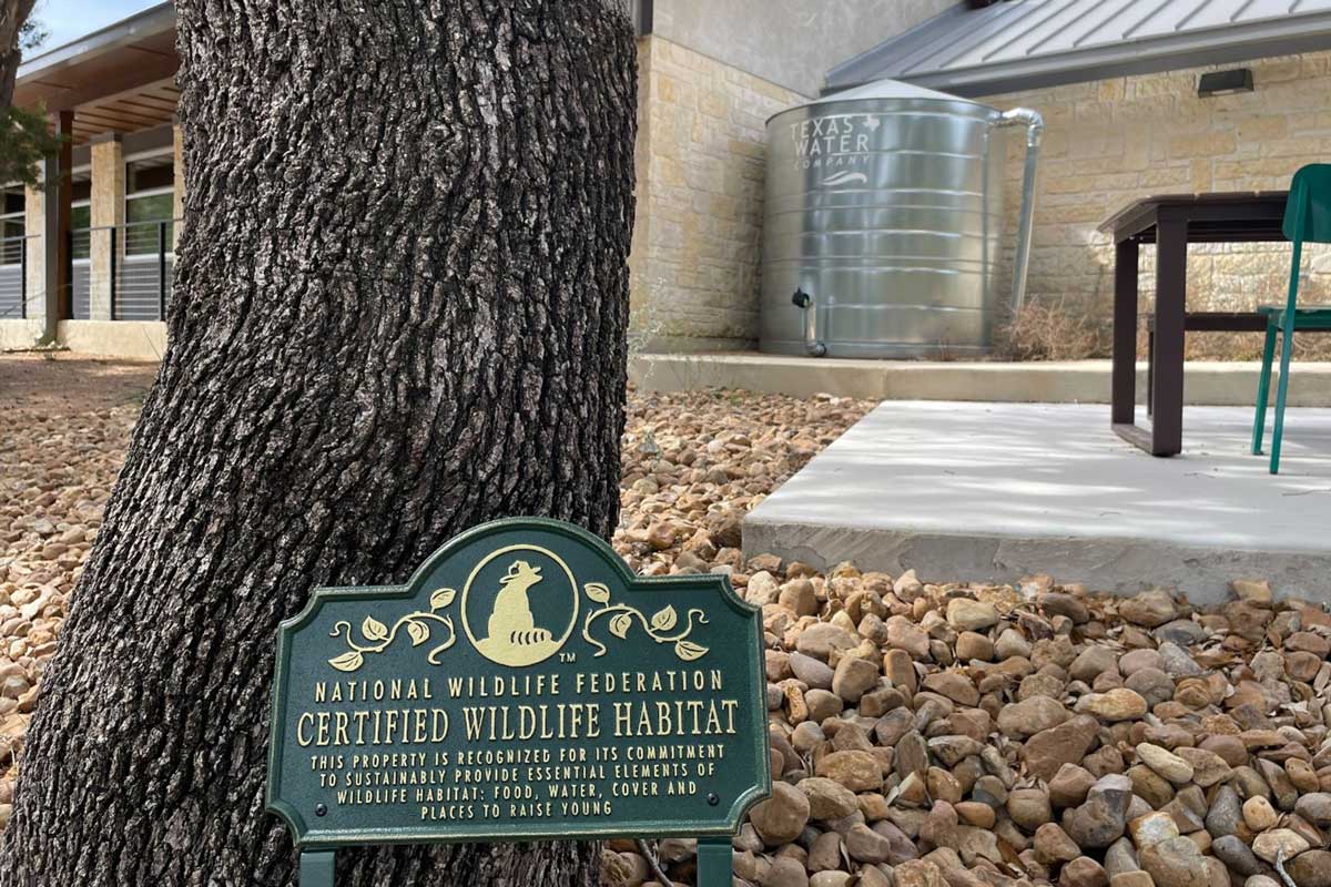 A sign designating Texas Water Company facility as a certified wildlife habitat.